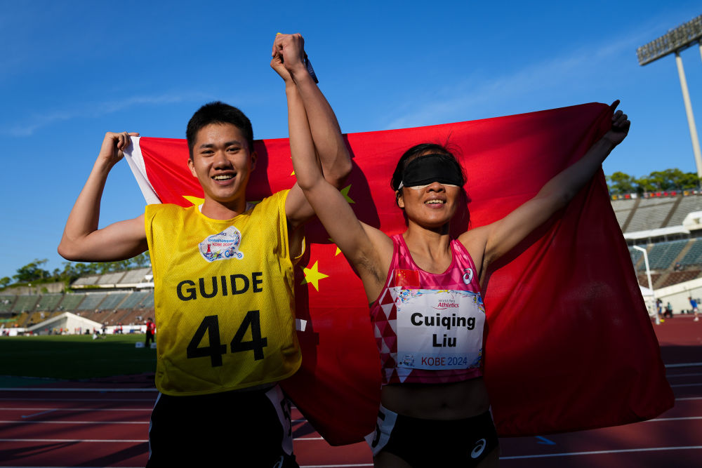 图为5月25日，中国选手刘翠青（右）和领跑员陈圣明在女子200米T11级别决赛后庆祝  